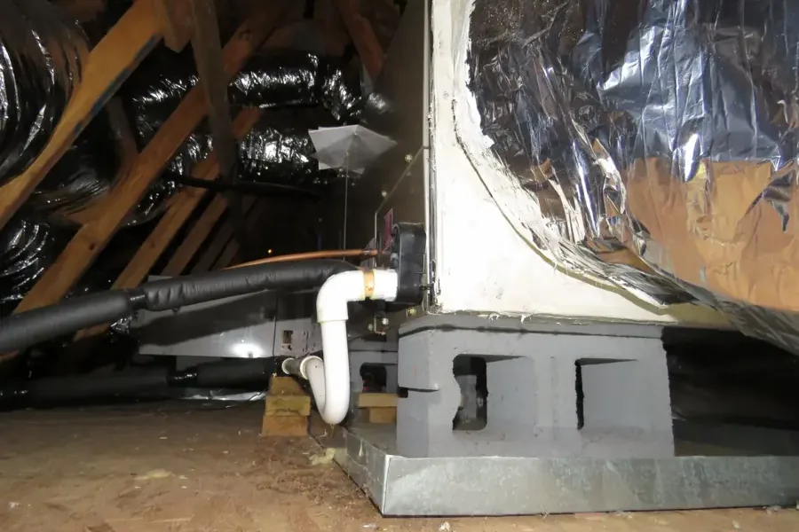 Attic air handler on a platform with its condensate drain line and pan